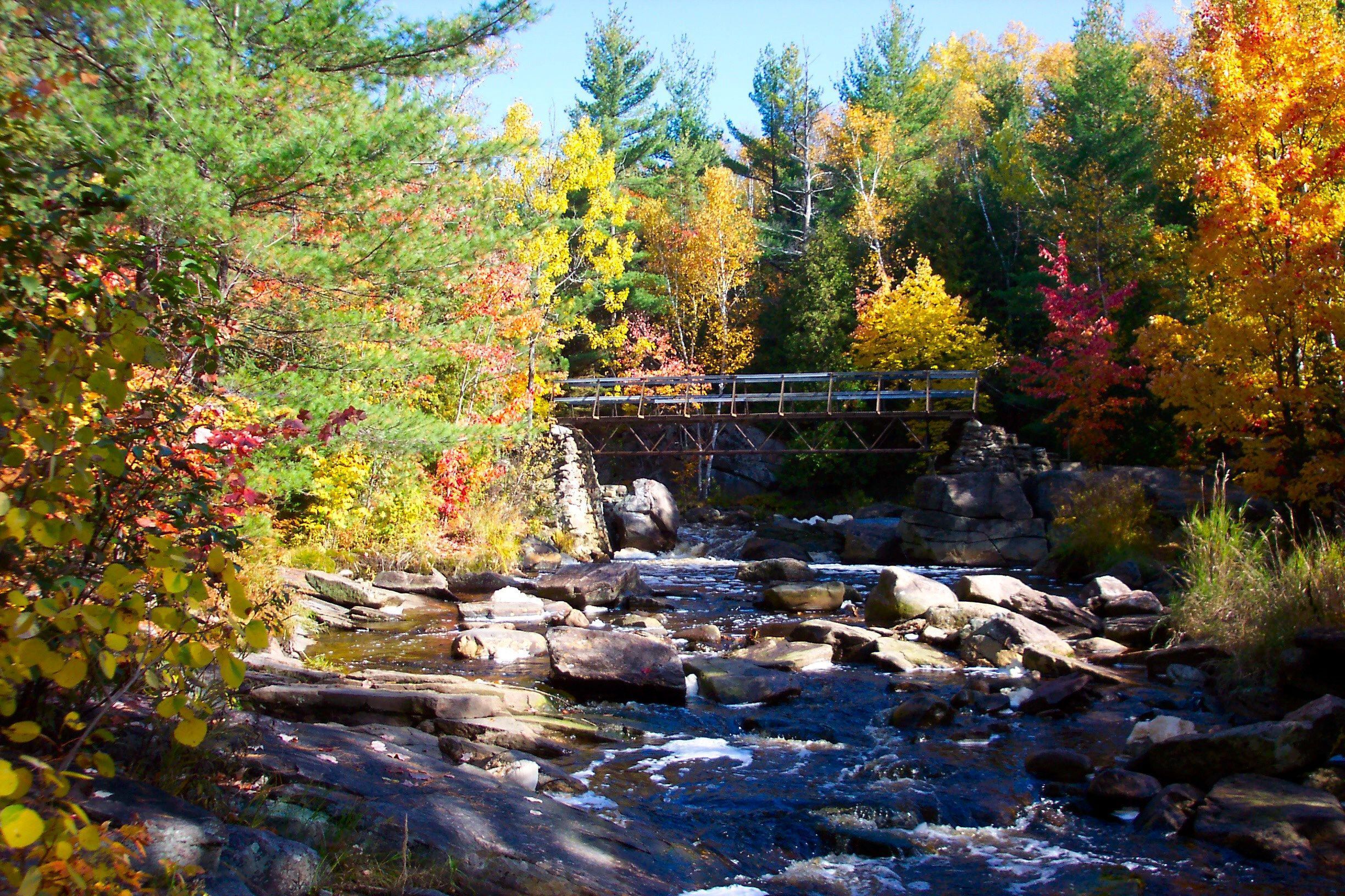 Un des petits paliers des chutes Duchesnay, à North Bay. Tout autour, les arbres sont verts, d'un jaune profond ou orange et rouge.
