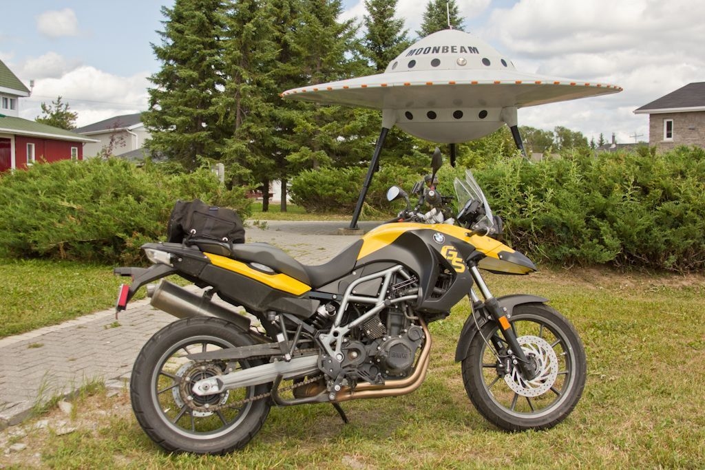 Une moto est stationnée devant la soucoupe volante de Moonbeam.