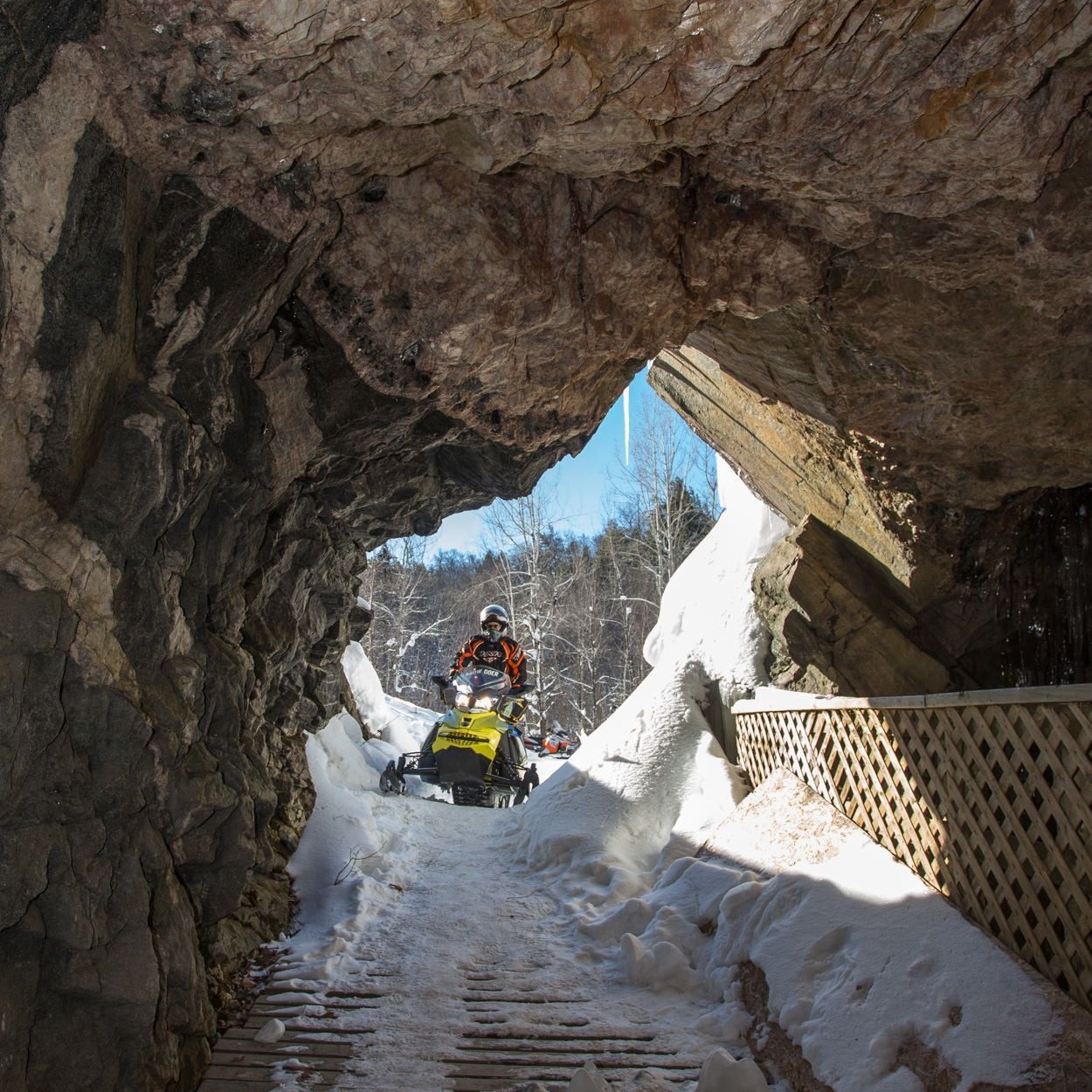 Quelqu'un en motoneige se transforme en tunnel rocheux.