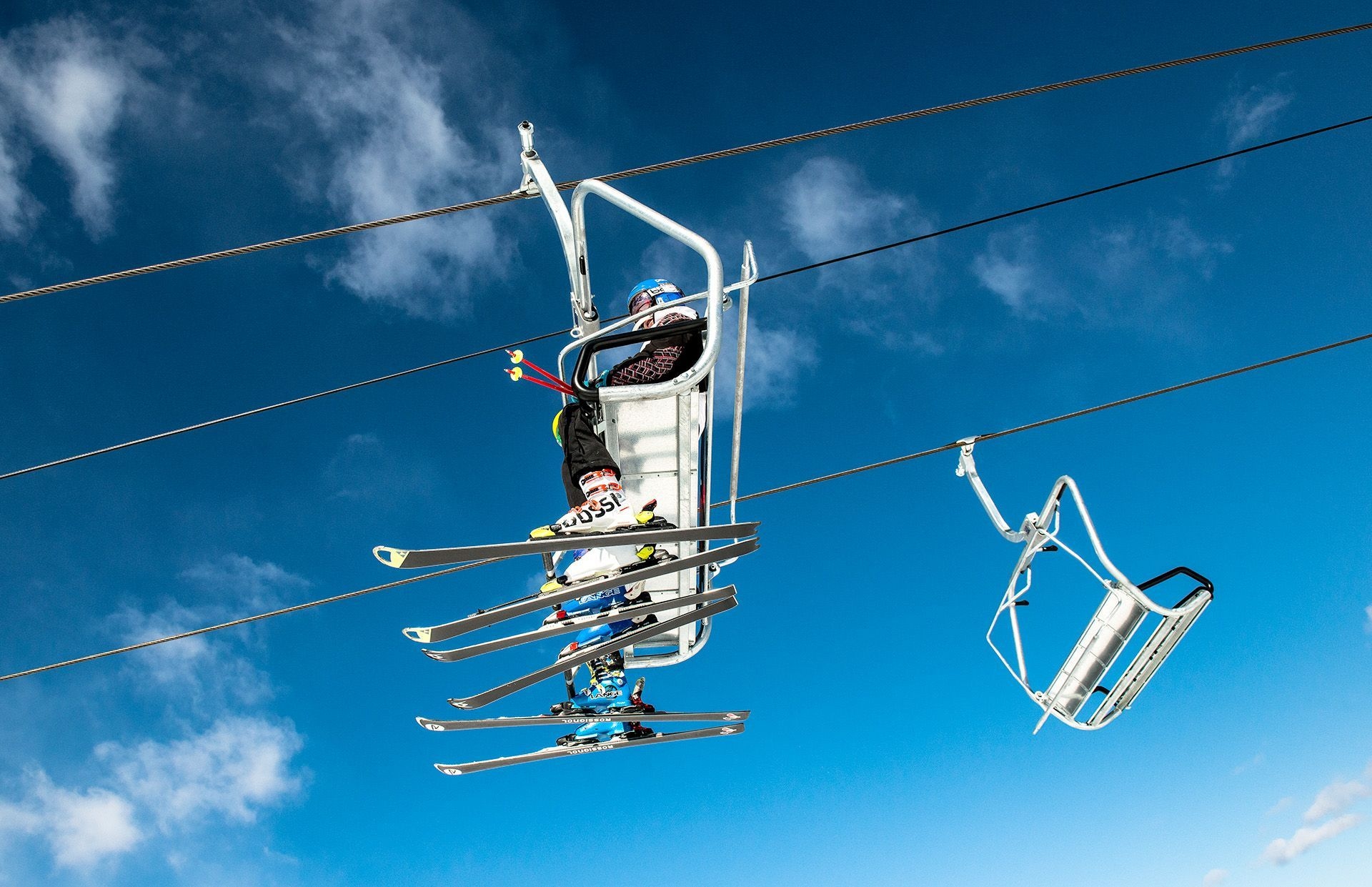 De la piste, on voit deux chaises de remontée mécanique, dont une qui transporte 4 personnes.