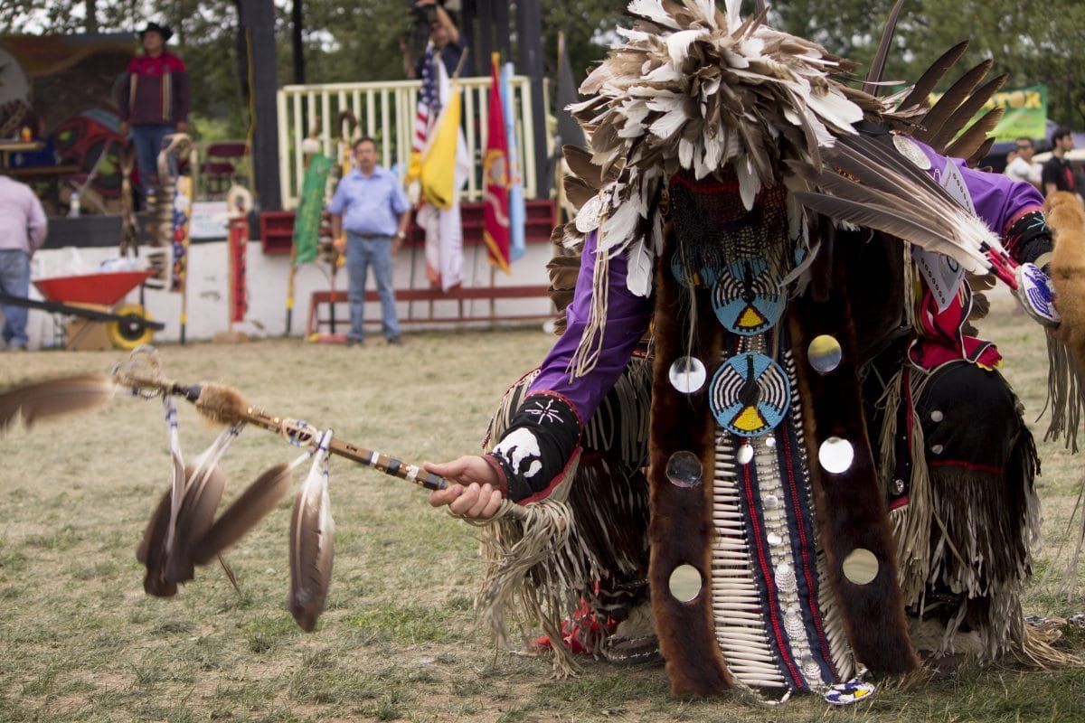 Un danseur vêtu d'une imposante regalia danse, lors d'un pow wow.