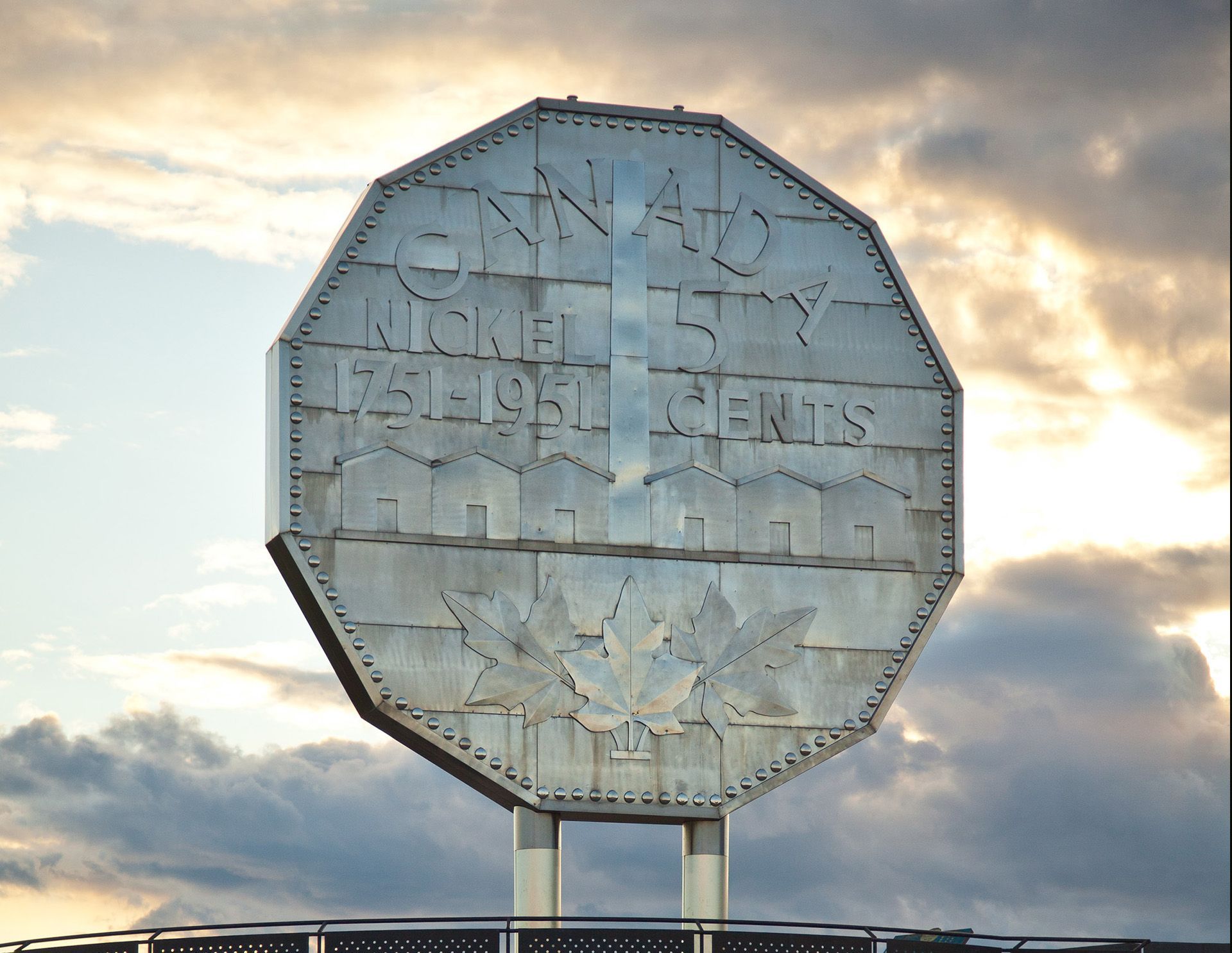 Le gros cinq cents de Sudbury se détache d'un ciel où les nuages laissent filtrer la lumière du soleil.